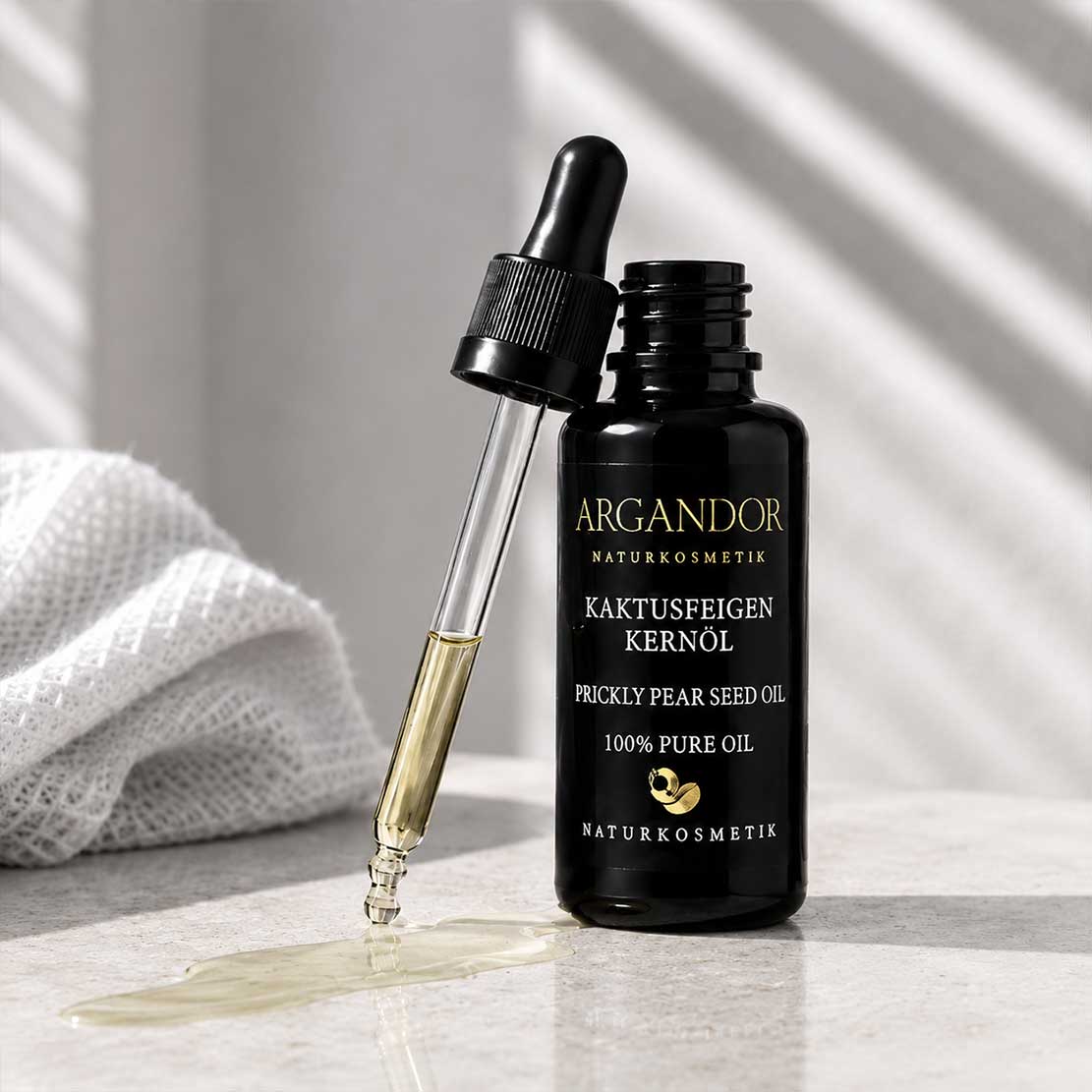 Argandor Kaktusfeigenkernöl 20 ml mit Kaktusfeige und Blüte auf hellem Naturstein